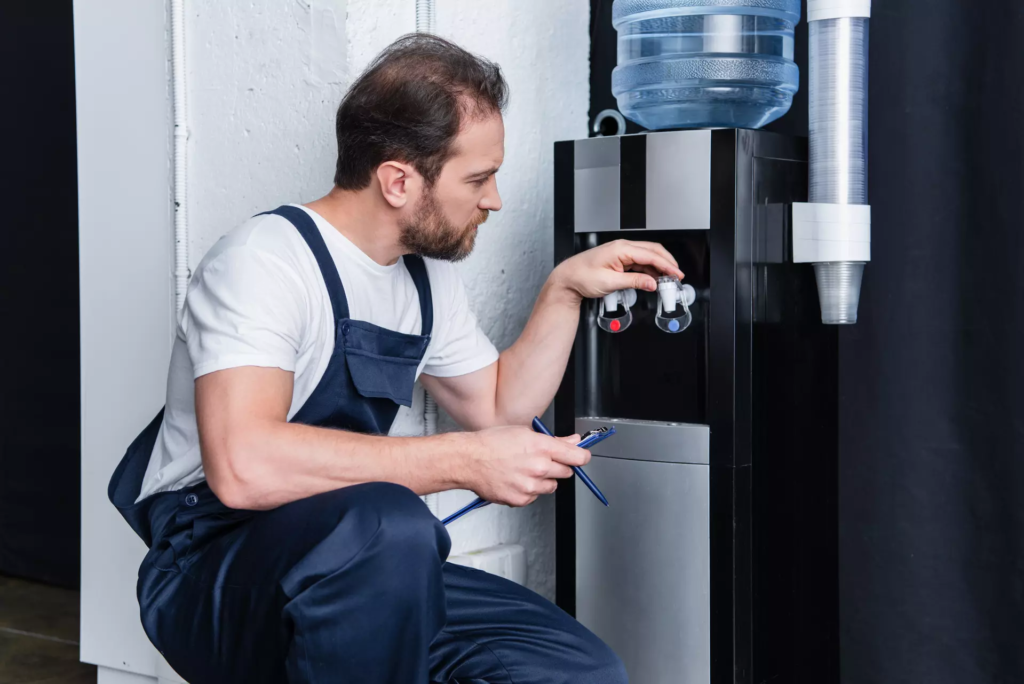 technicien qui fait la maintenance d'une fontaine a eau